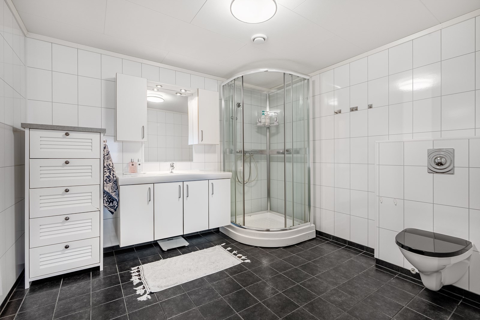 Badet er utstyrt med baderomsinnreiing, vegghengt wc og dusjkabinett. Galleribilde