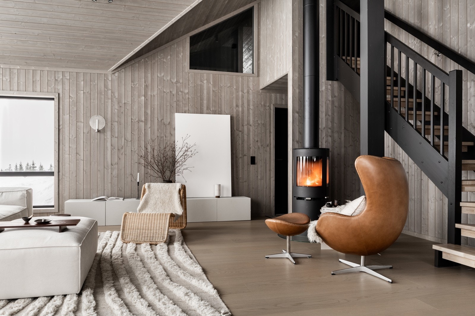 Tidsriktige farge- og materialvalg. Peis i stue som skaper god varme. Galleribilde