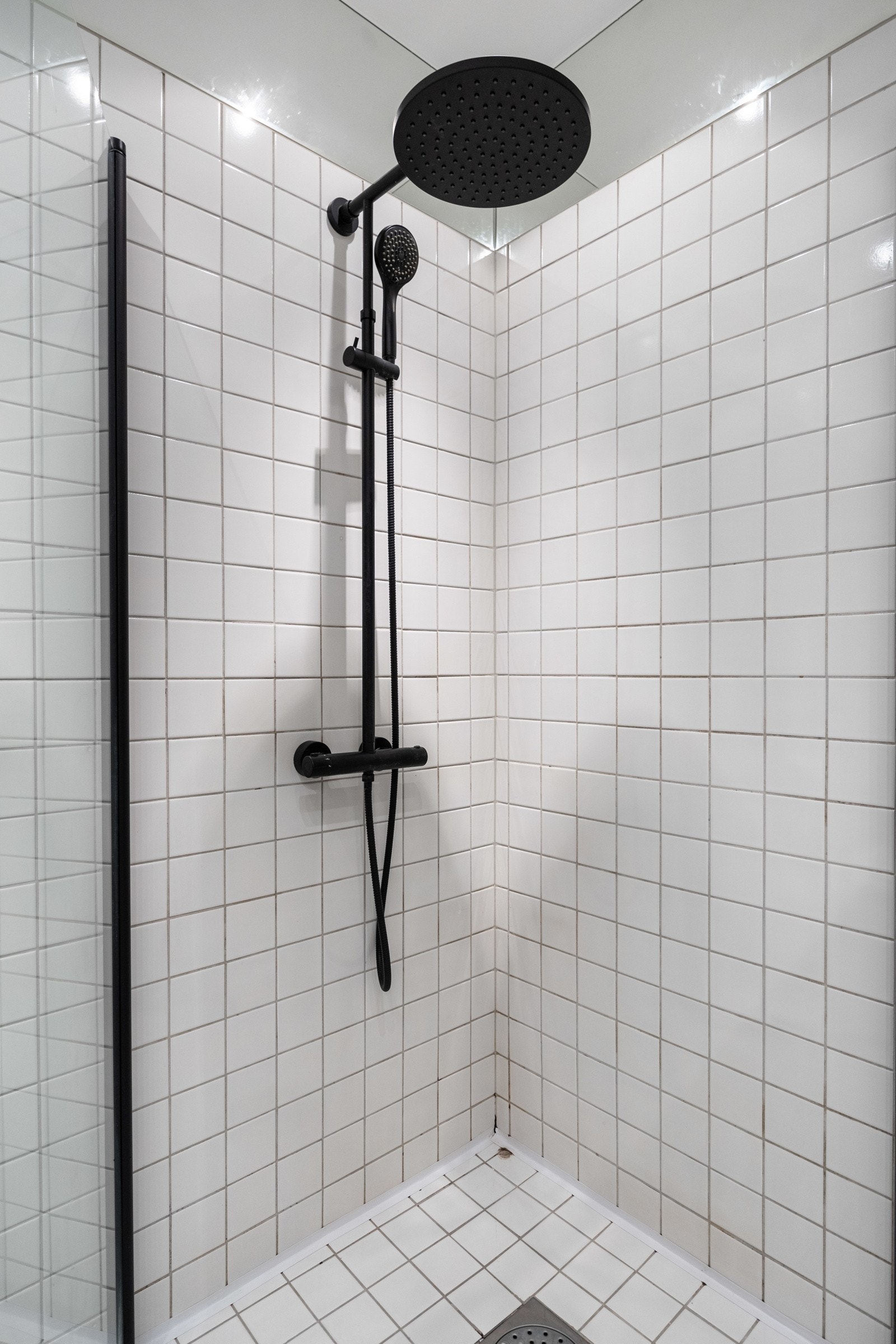 Dusjhjørne med glassdører og avtrekksvifte plassert i himling. Galleribilde