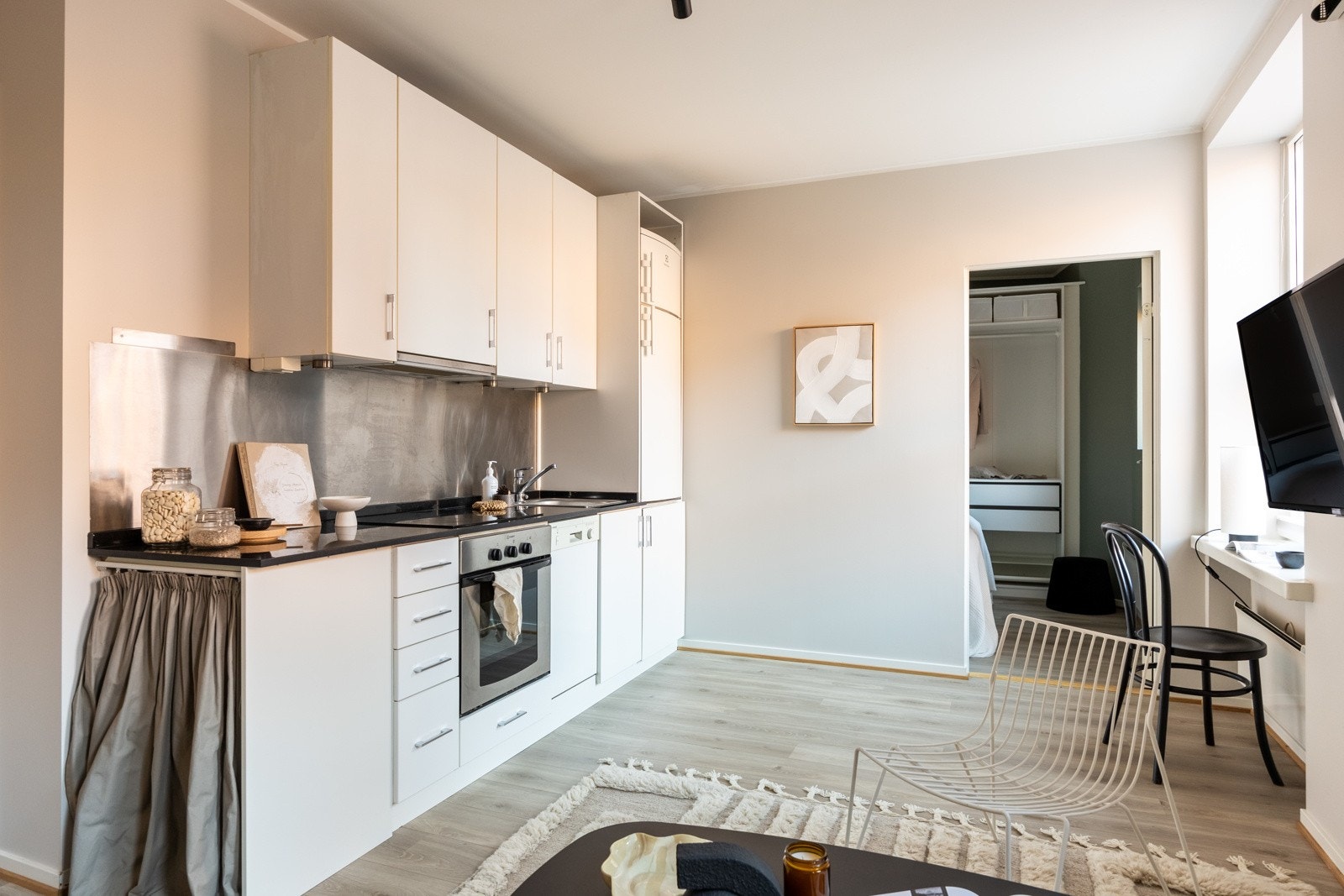 Kjøkkeninnredning med slette fronter og benkeplate av stein med nedfelt oppvaskkum. Galleribilde