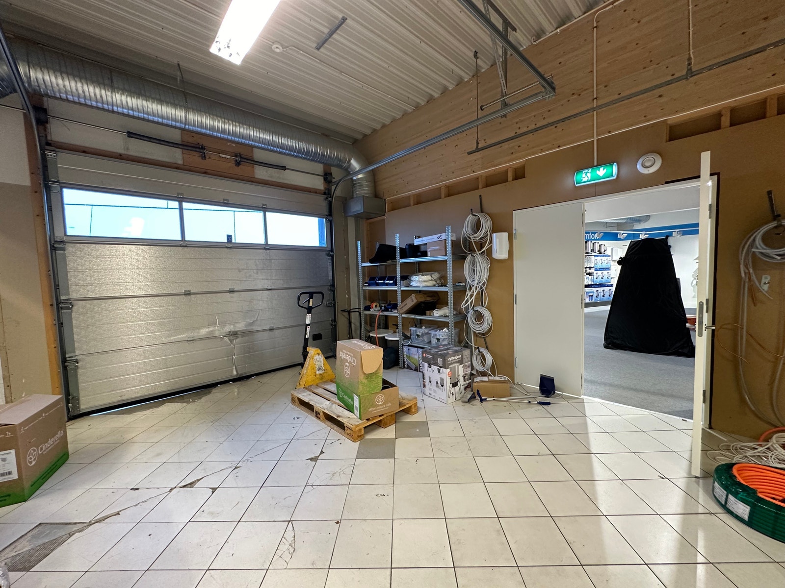 Lager med kjøreport ut på baksiden av bygget, og dør inn til åpent areal/butikk. Galleribilde