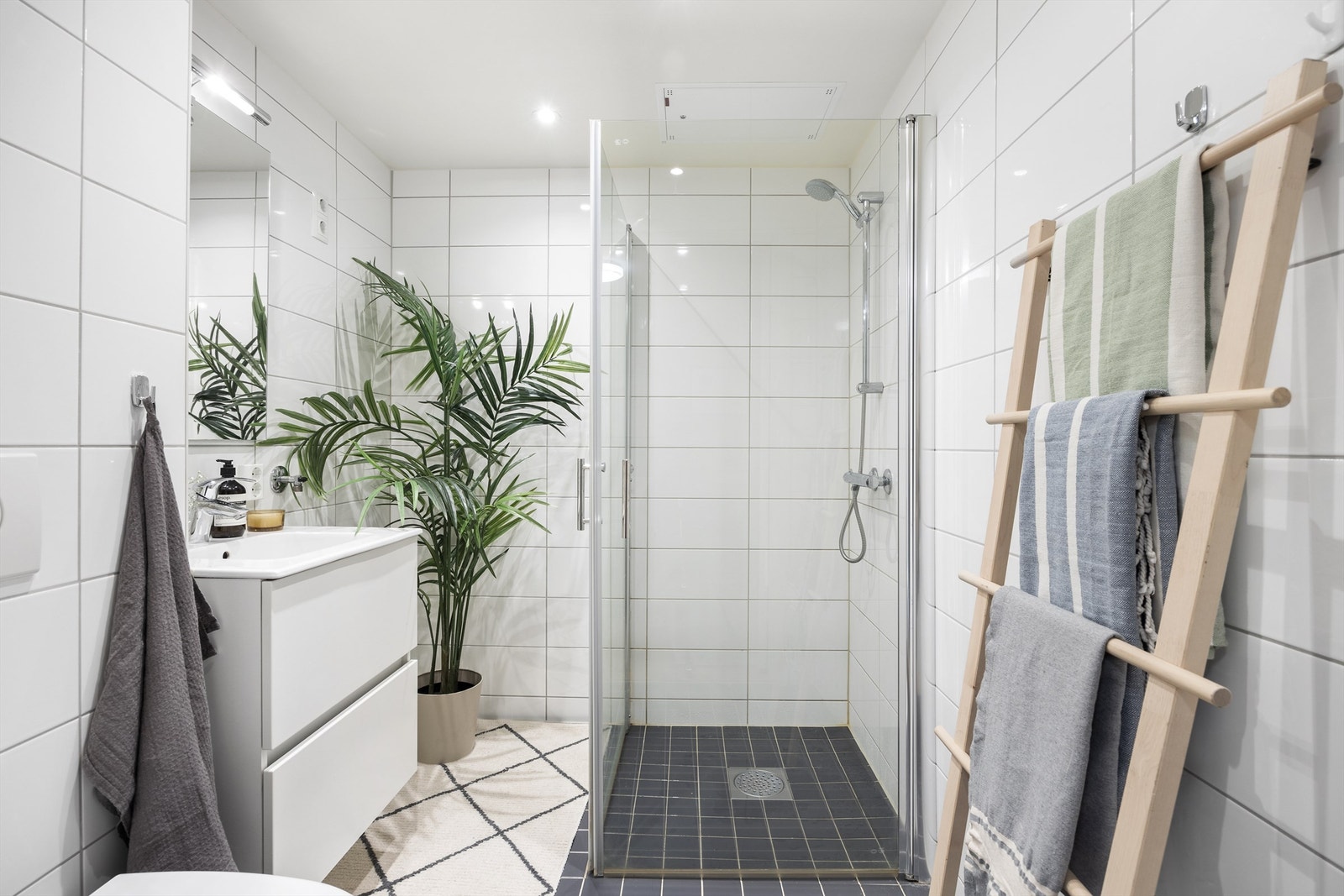 Lekkert baderom med gulvvarme, downlights i nedsenket himling med dimmer og opplegg for vaskemaskin Galleribilde