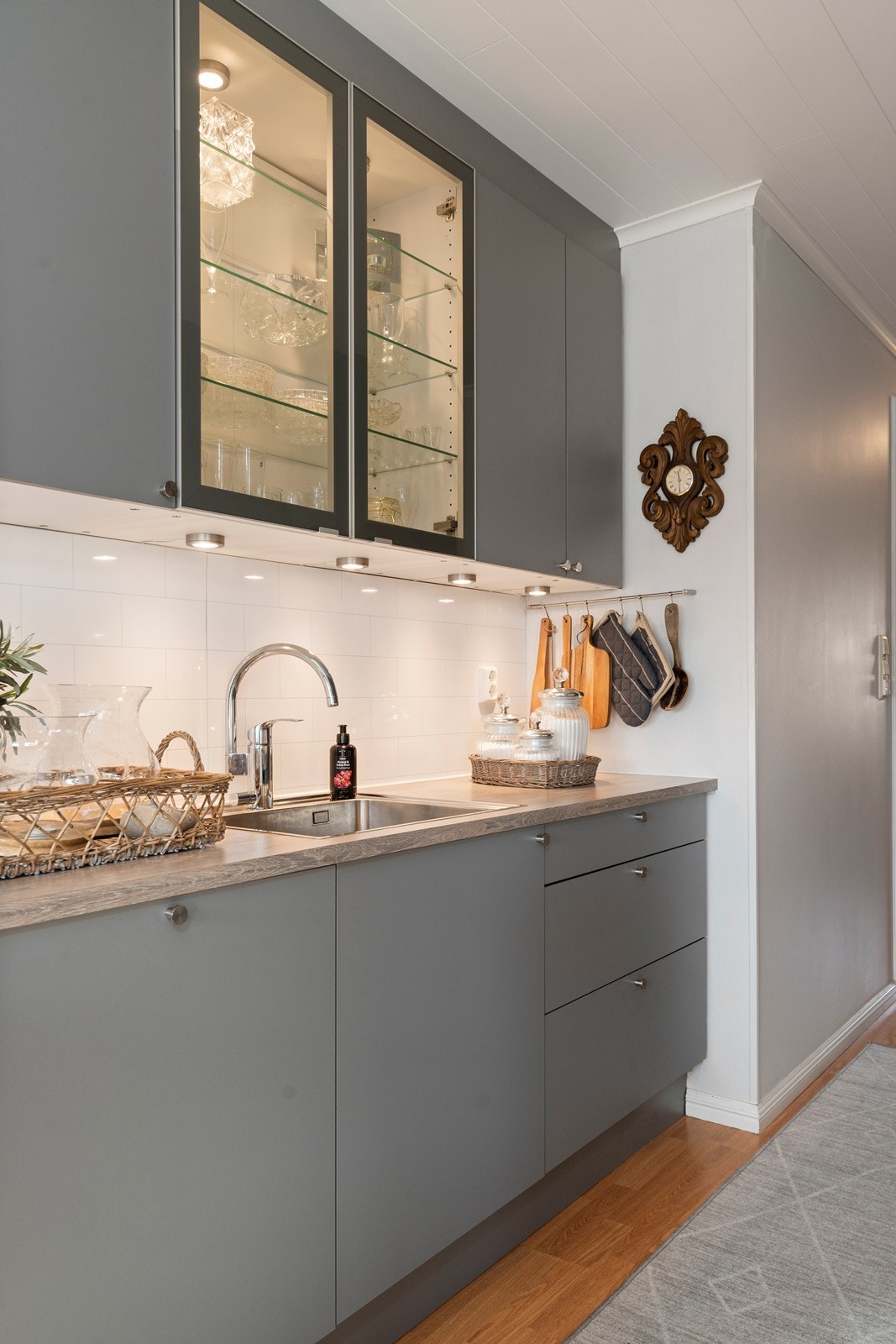 Kjøkkeninnredningen har både over- og underskap, med fliser over benk Galleribilde