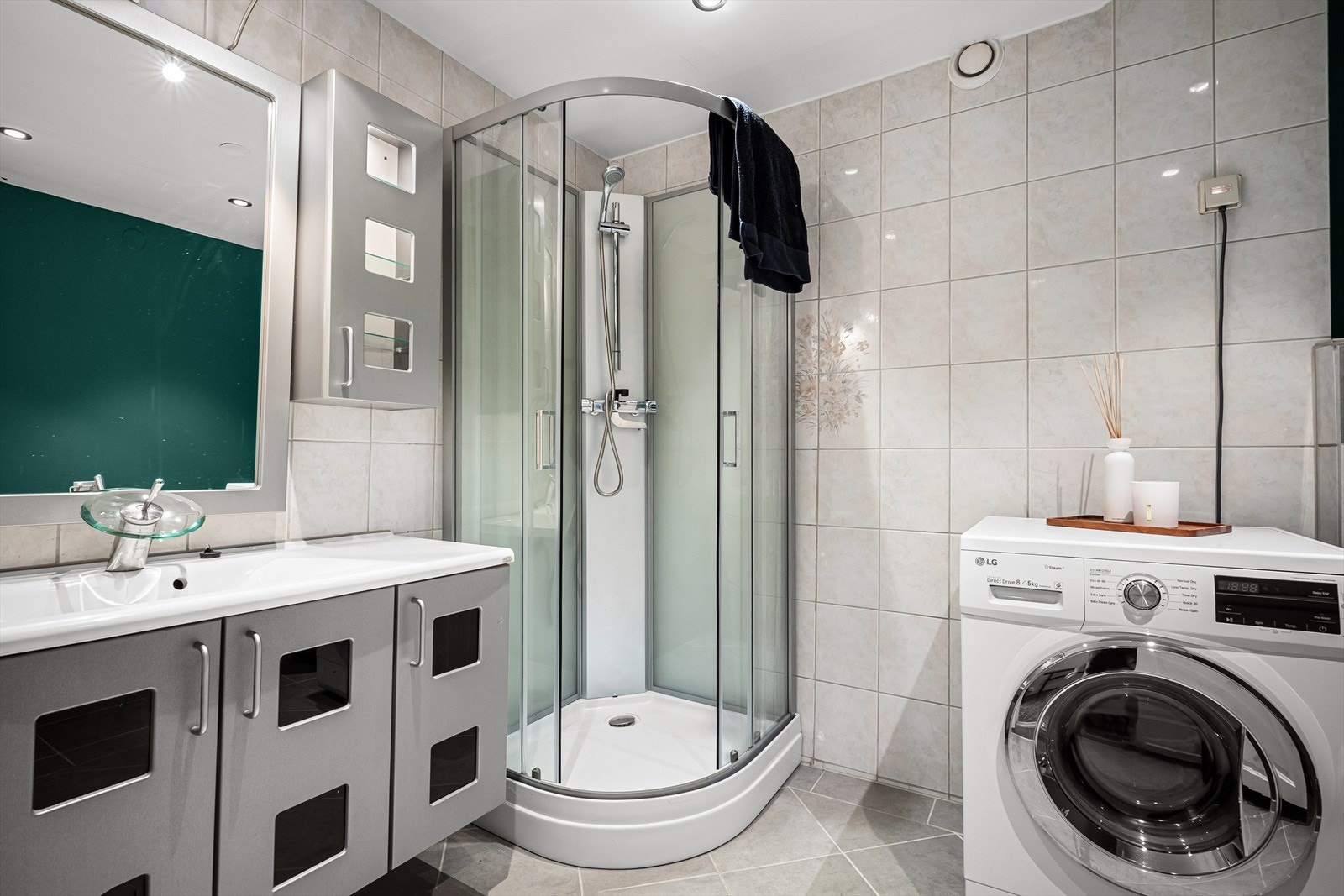 Romslig bad med fliser på gulv og vegger med unntak av toalettsone. Galleribilde