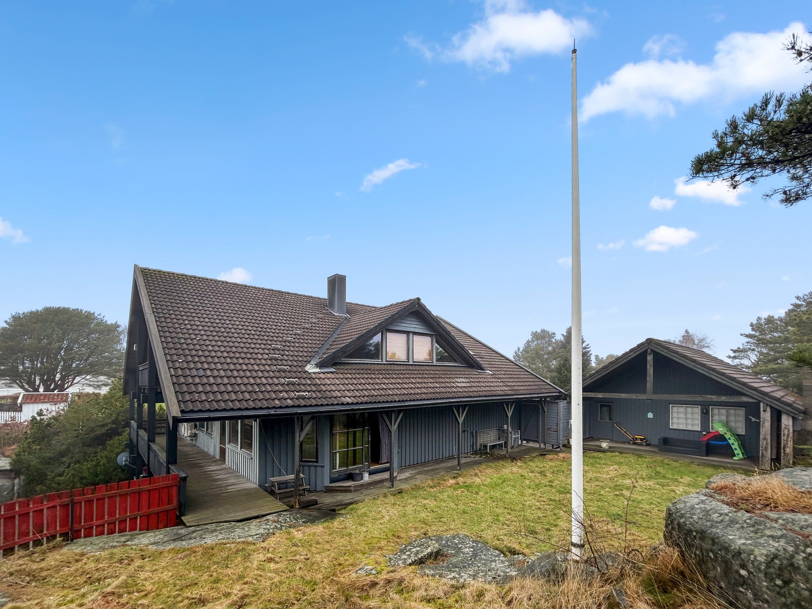 Fasade, her ser du hagen samt ned mot terrassen på fremsiden av huset Galleribilde