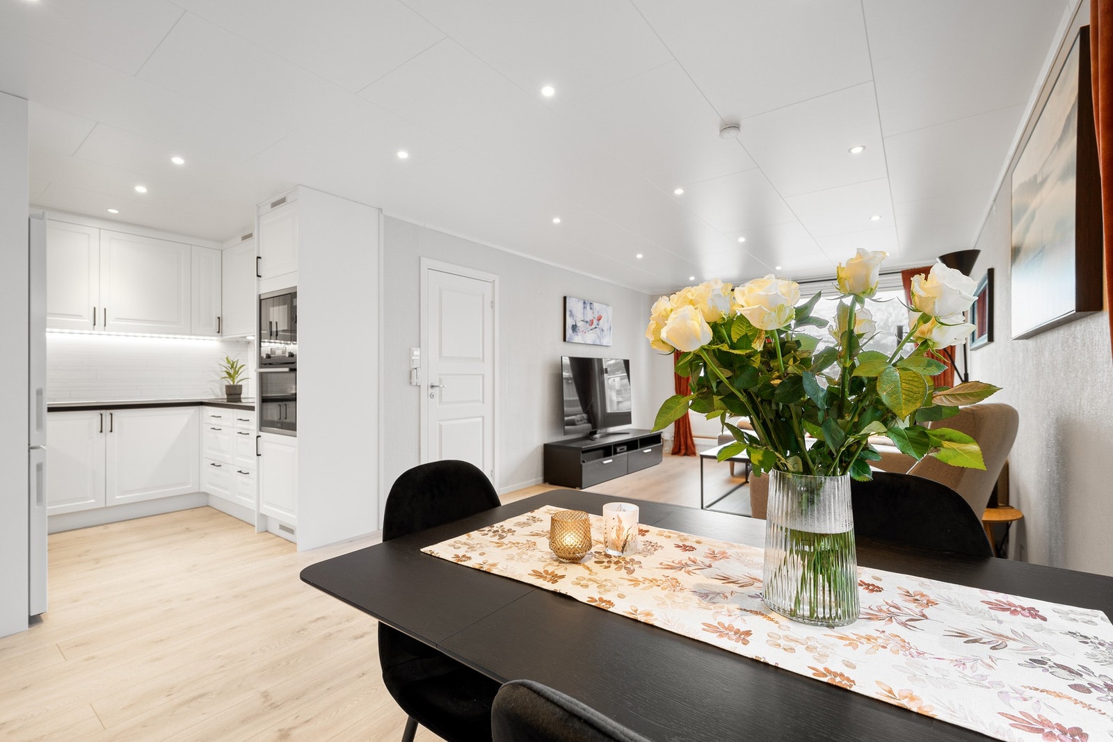 Delvis åpen kjøkkenløsning som er vendt mot spisestuen Galleribilde