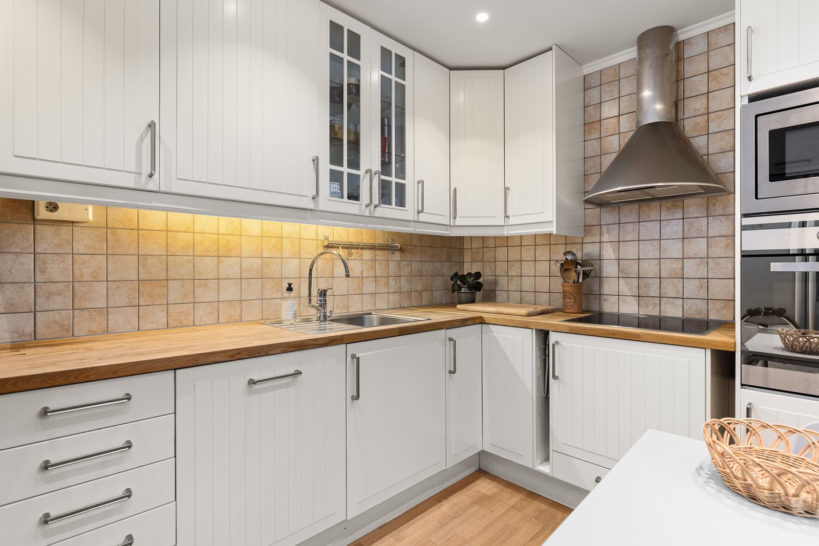 Innredningen er praktisk og stilfullt innredet med Ikea-kjøkkeninnredning med profilerte fronter og benkeplate i heltre eik. Mellom over- og underskapene er det fliser på veggen. Galleribilde