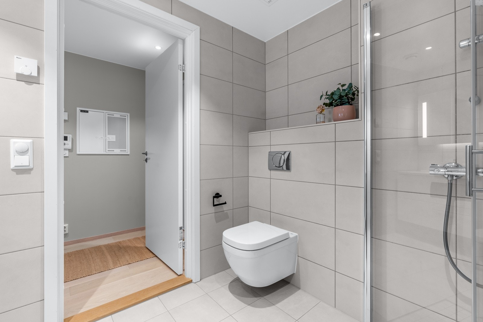 Delikat baderom med gulvvarme og opplegg for vaskemaskin og tørketrommel Galleribilde