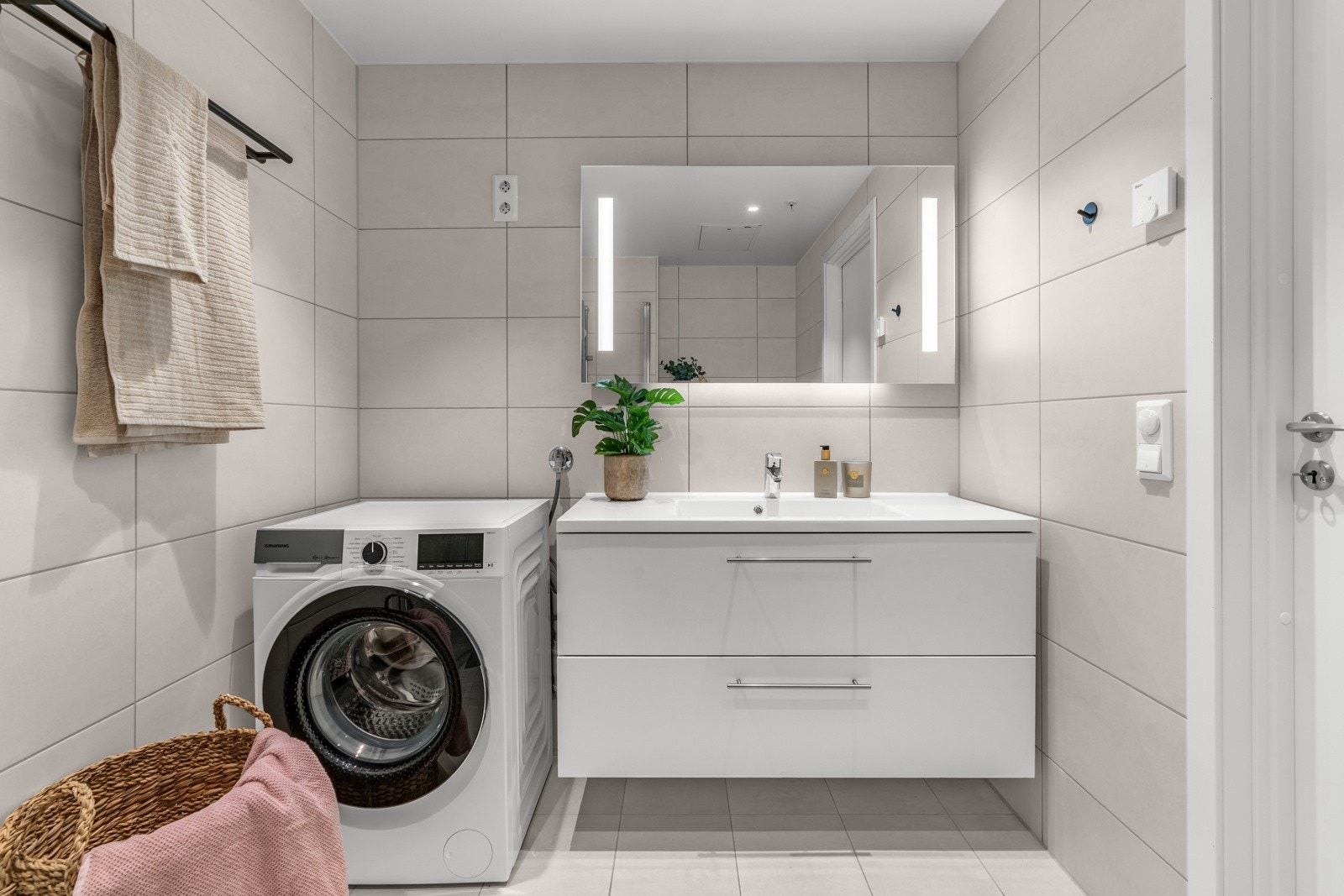 Delikat baderom med gulvvarme og opplegg for vaskemaskin og tørketrommel Galleribilde