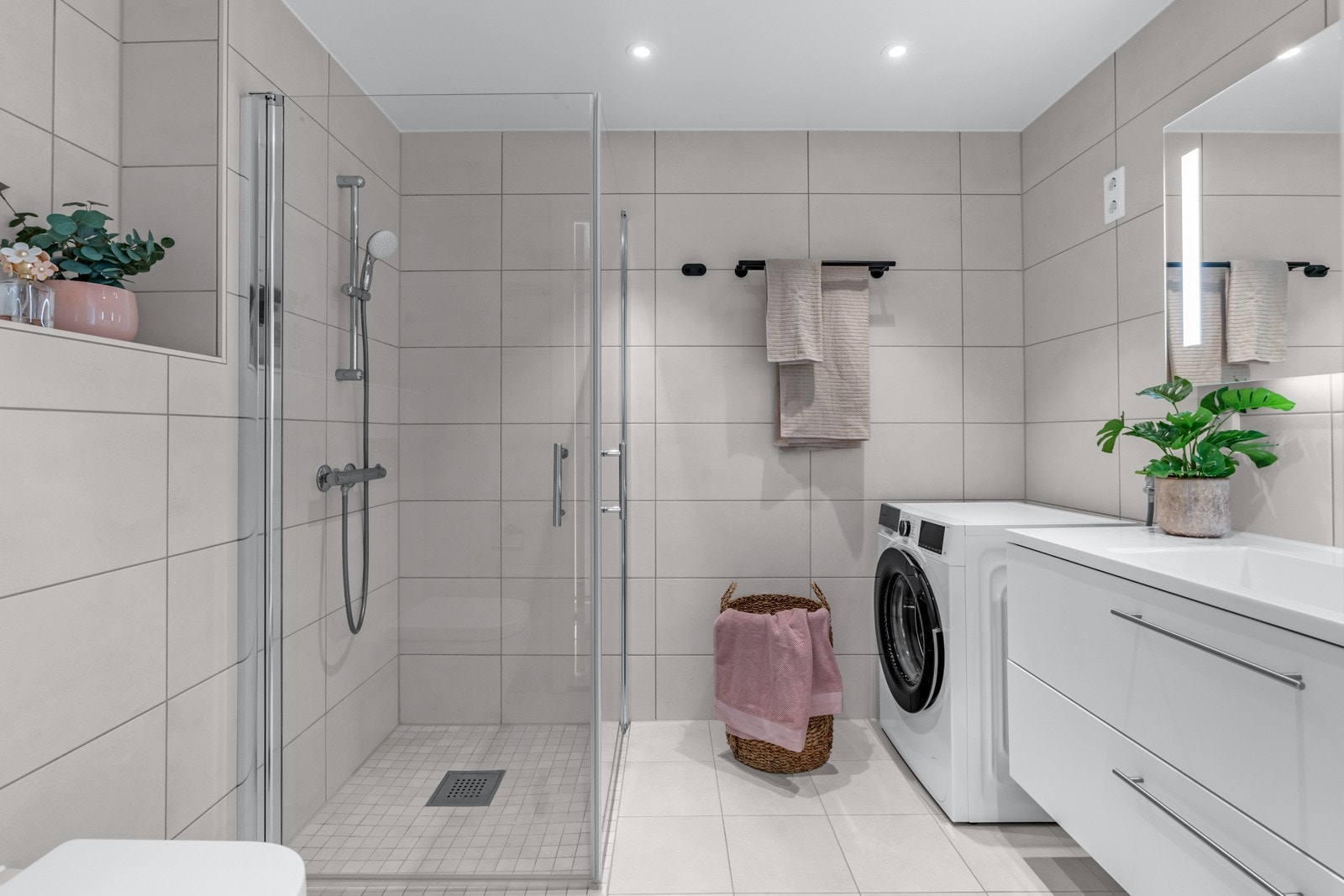 Delikat baderom med gulvvarme og opplegg for vaskemaskin og tørketrommel Galleribilde