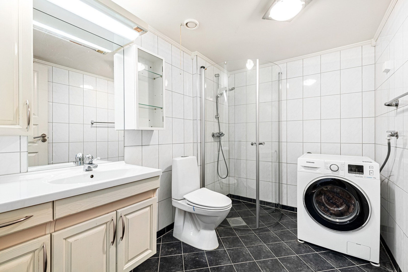 Flislagt bad med opplegg til vaskemaskin. Galleribilde