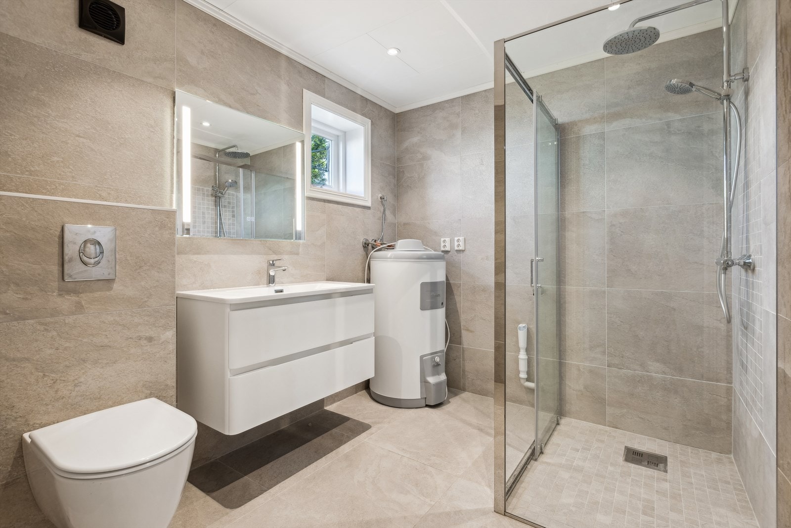 Det andre baderommet er beliggende i boligens underetasje. Baderommet her er også med varmekabler og fliselagte overflater på vegger og gulv. Galleribilde