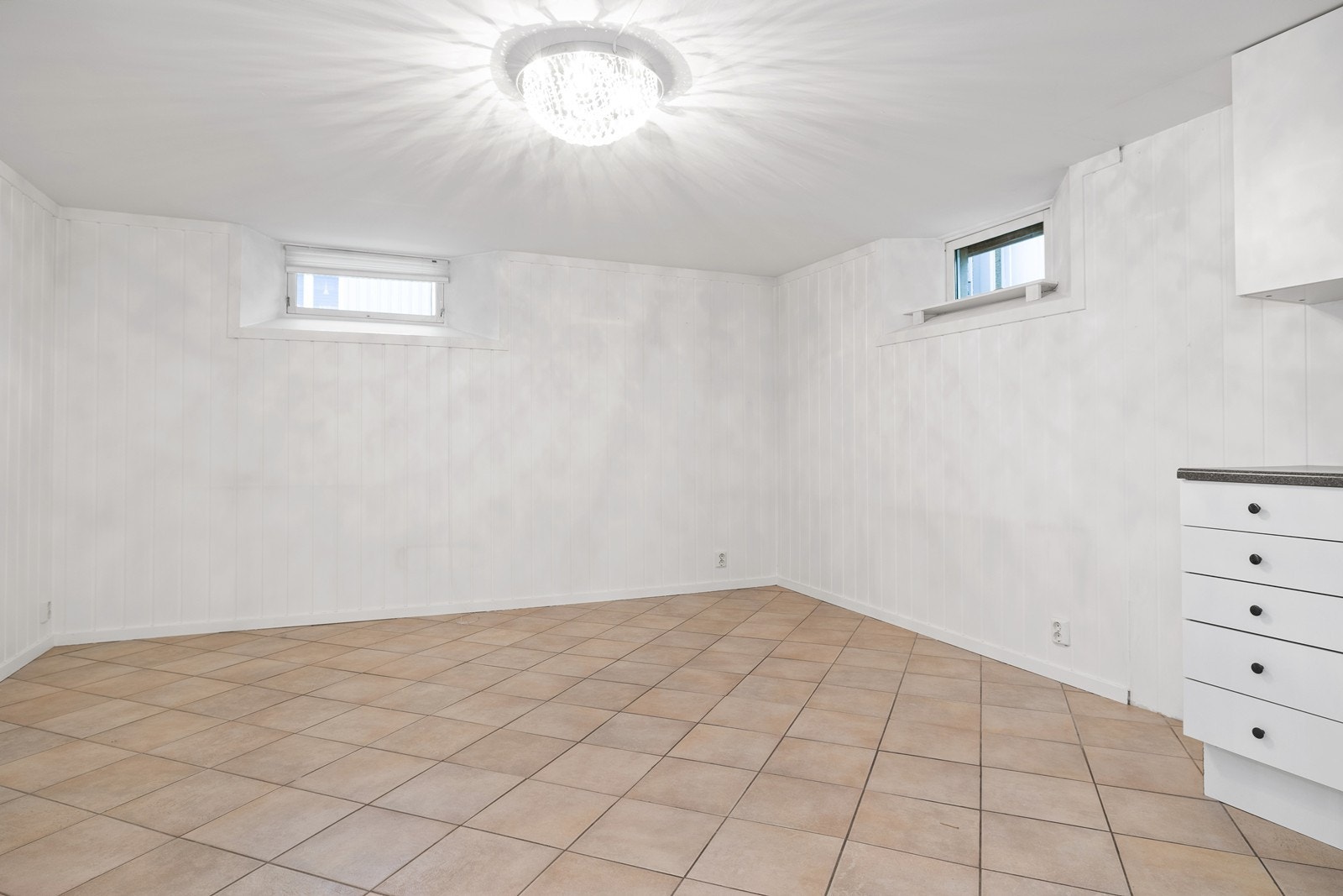 Kjeller - Kjøkkenkrok og Stue med lyse overflater Galleribilde