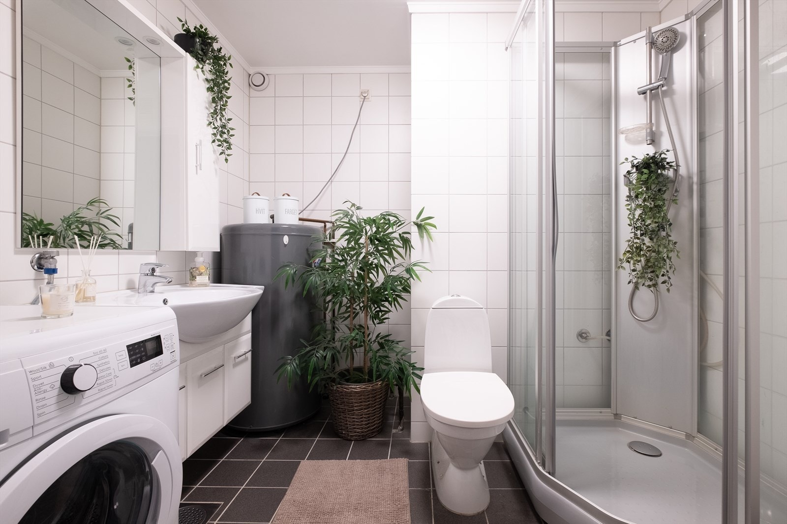 Leiligheten har et romslig og lyst bad med flislagte overflater med varmekabler i gulvet Galleribilde