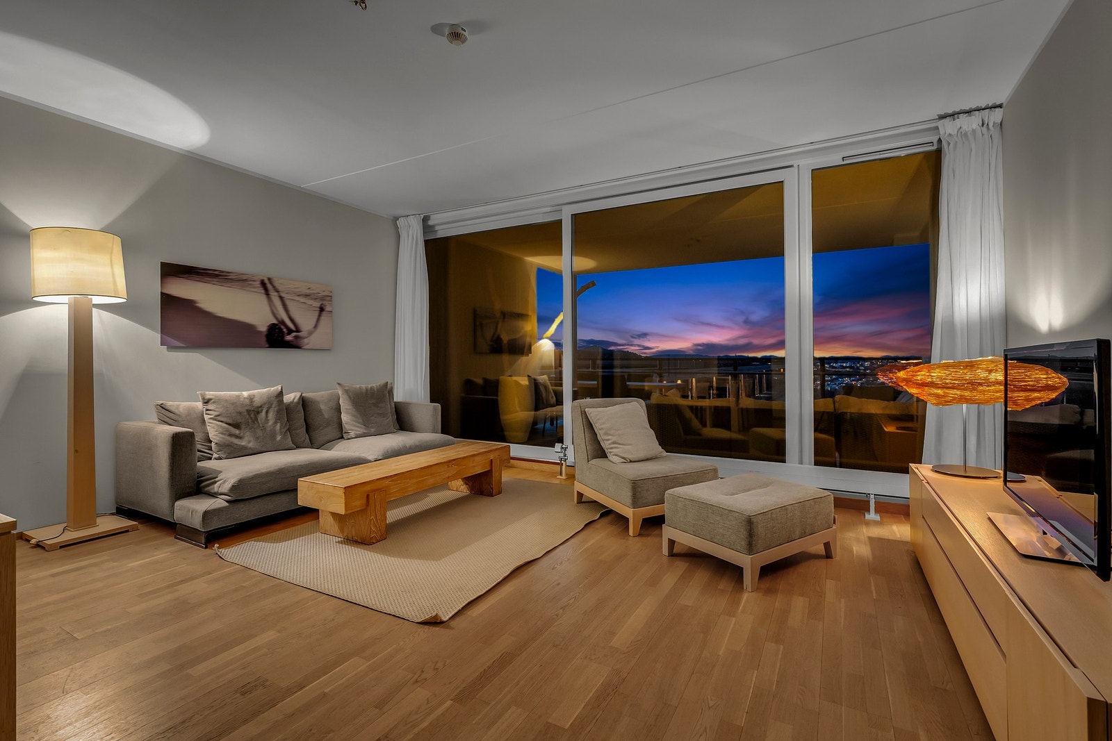 Koselig stue med store vinduer som slipper inn naturlig lys. Galleribilde