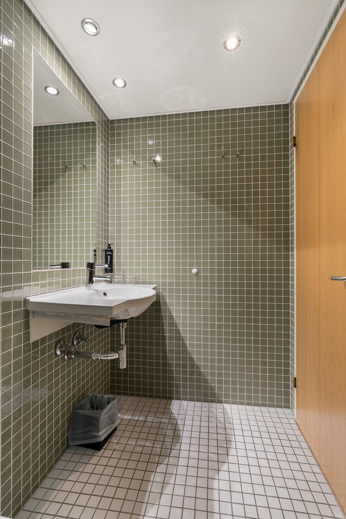 Vegghengt toalett og dusjhjørne med dusjvegger i herdet glass. Galleribilde