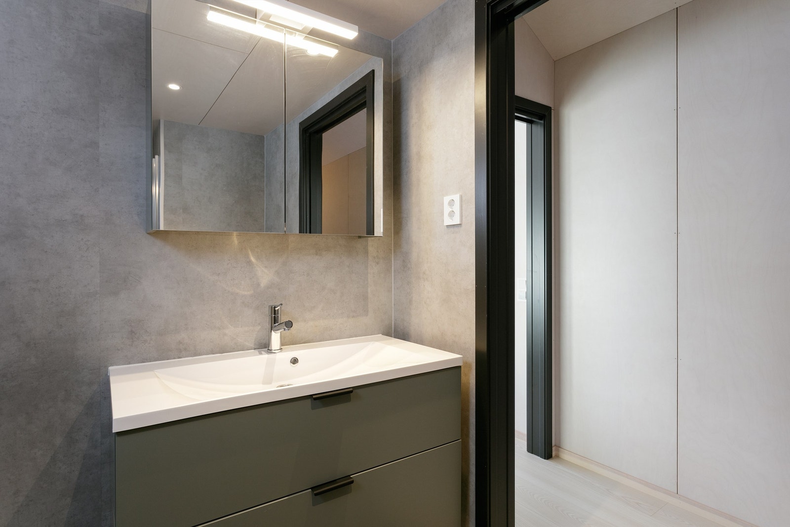 Baderomsinnredning med speilskap med overlys og stikkontakter over servant Galleribilde