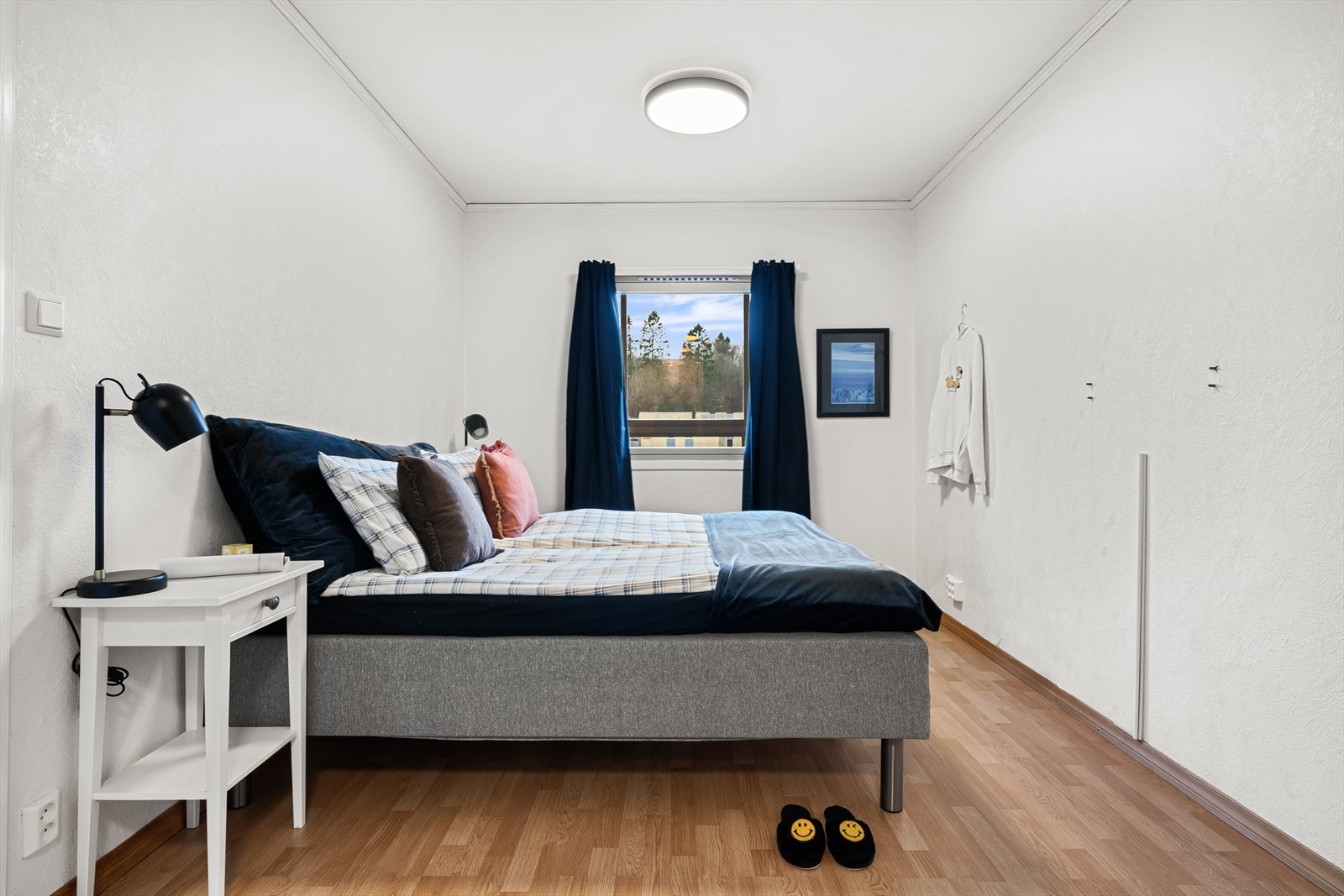 Lyst soverom med nøytrale farger og stort vindu som slipper inn rikelig med naturlig lys. Galleribilde