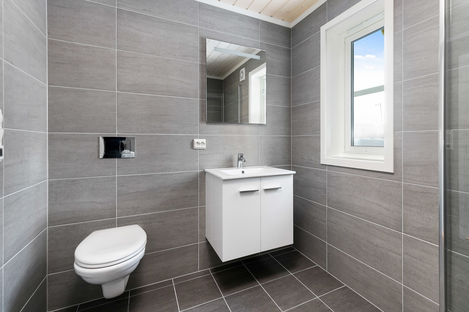 På badet er det lekre fliser på vegg og gulv med termostyrte varmekabler. Bilder er ikke av den aktuelle hytta, men tilsvarende modell. Galleribilde