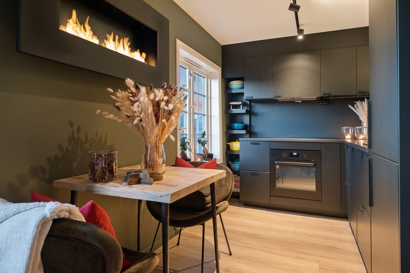 Stilig kjøkken med folierte skrog med slette fronter og laminert benkeplate. Plater på vegg over benkeplate. Galleribilde