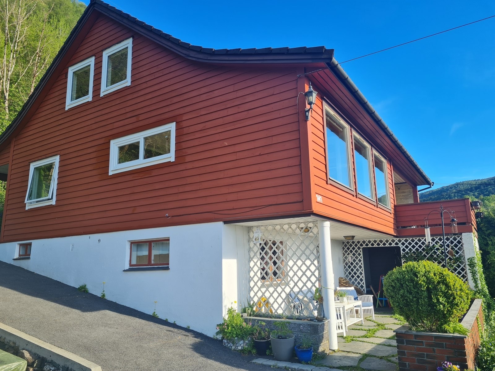 Det er fleire kjekke uteplassar på eigedommen, med god plass til sittegruppe i framkant av underetasjen, terrasse med utgang frå stova og på toppen av garasjen Galleribilde
