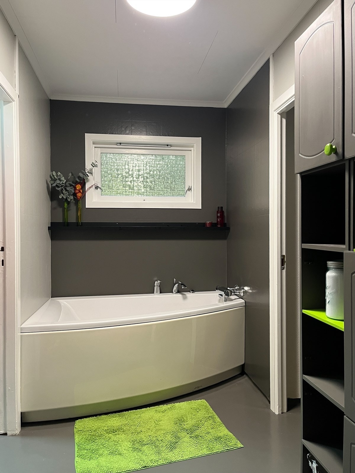 Badet og toalettrommet har måla overflater og er inndelt i fleire soner. Den midterste delen består av servant med møbel og skap og badekar Galleribilde