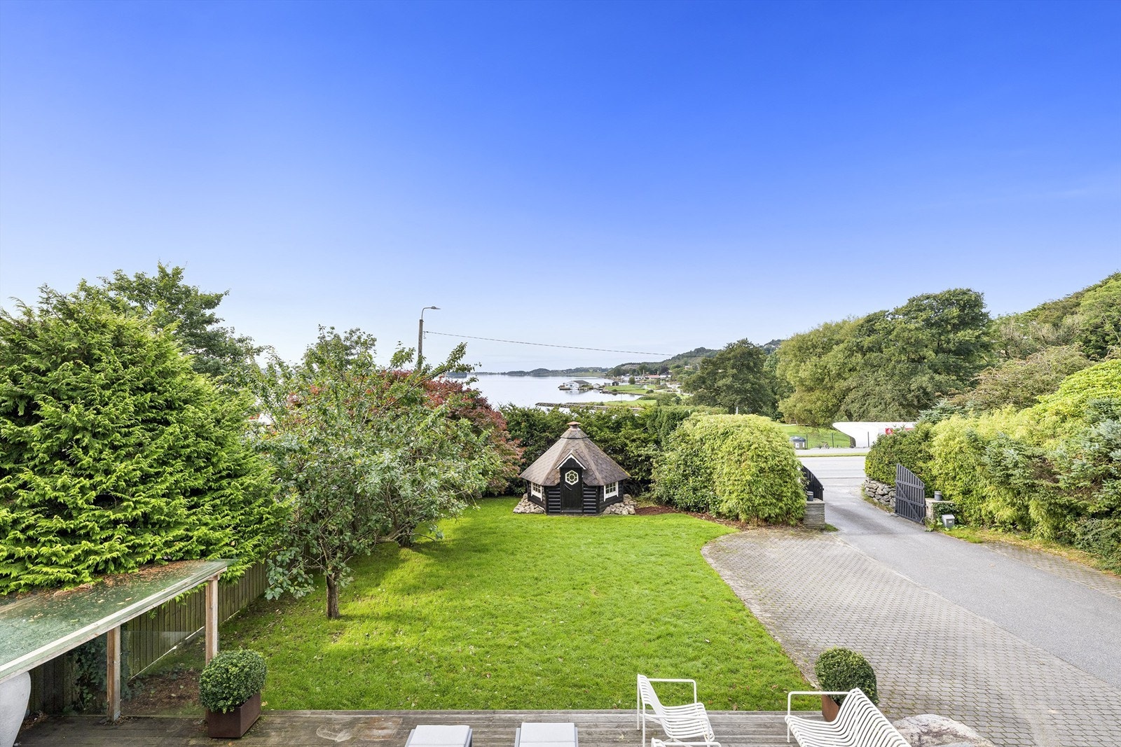 Pent oparbeidet tomt. Fint beplantet og opprbeidet med pergola og grillhytte (plassert utenfor byggegrensen) Galleribilde