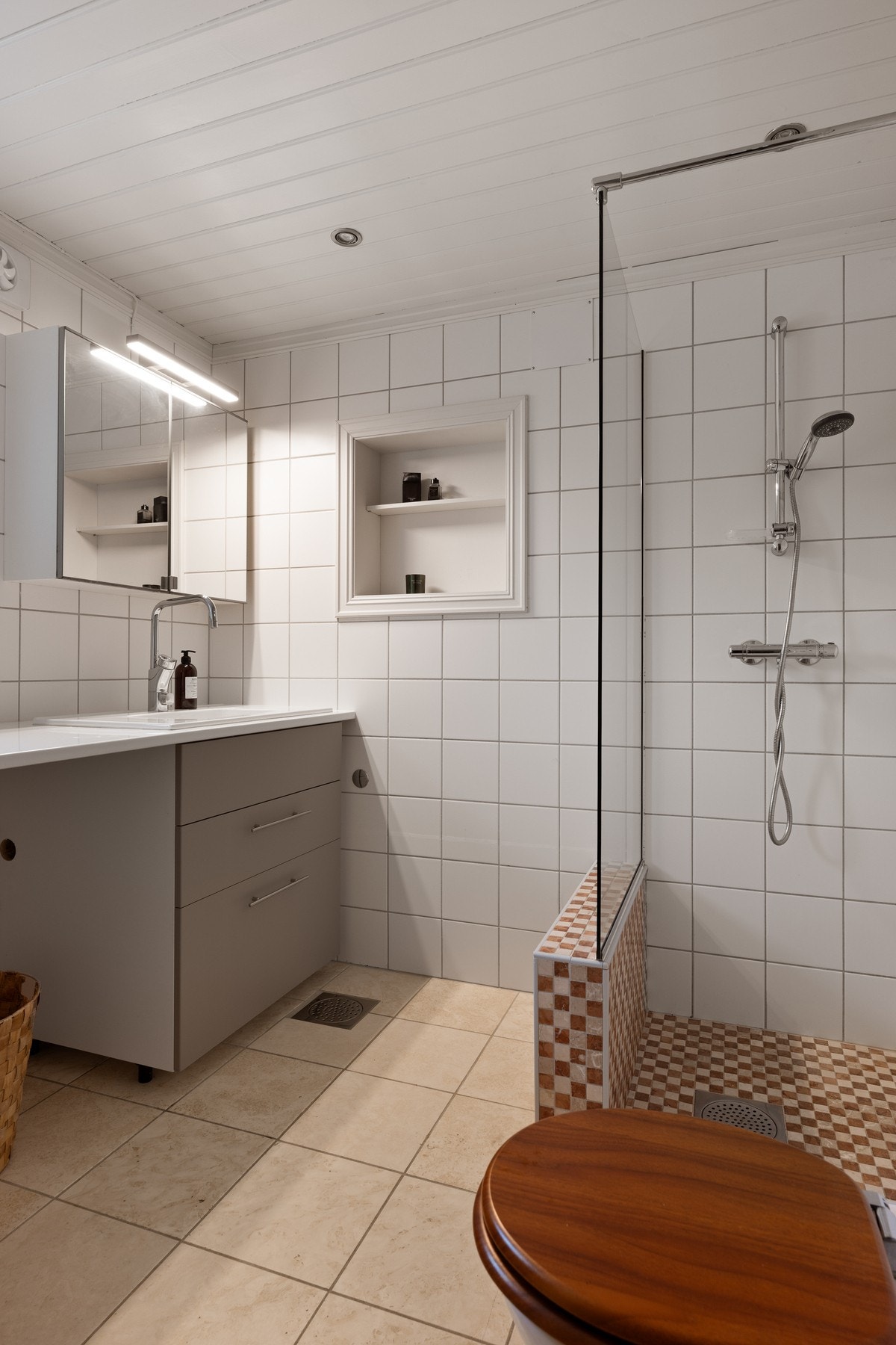 Bad i 1. etasje fra 2007. Rommet har innredning med nedfelt servant, veggfestet toalett og dusjhjørne. Galleribilde