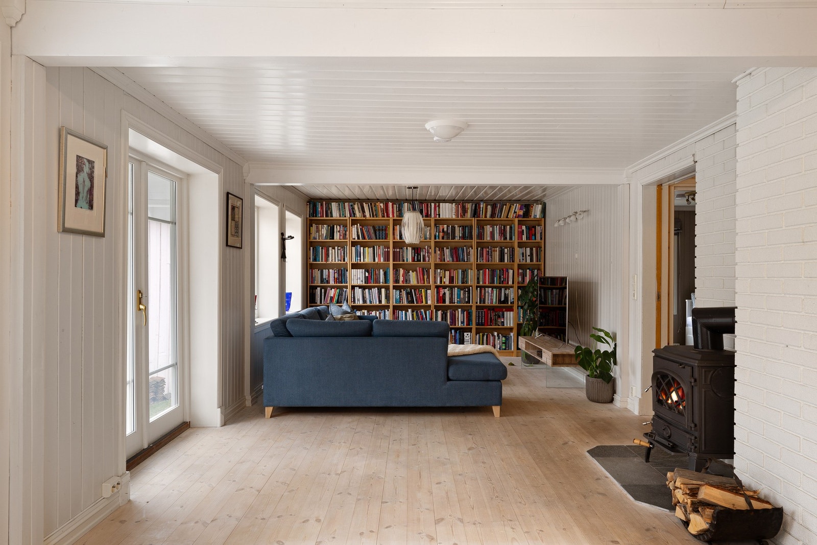 Vi kommer videre inn i stuen med plassbygd bokhylle og peis. Galleribilde