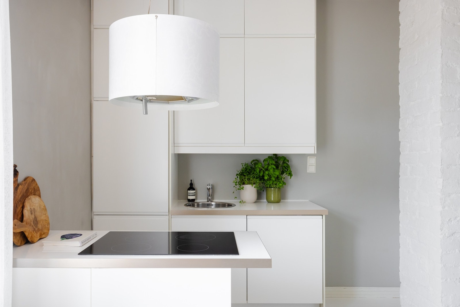 Innredningen består av hvite glatte fronter, laminat benkeplate og nedfelt vask med ett-greps blandebatteri. Hvitevarene inkluderer integrert kjøl/frys, oppvaskmaskin, ovn og induksjonstopp. Galleribilde