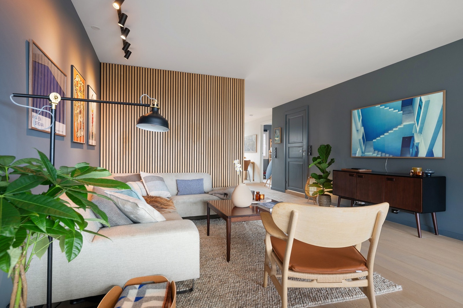 Stuen fremhever elegant design med en dekorativ spilevegg og lunt parkettgulv med integrert gulvvarme, som skaper en innbydende og komfortabel atmosfære. Galleribilde