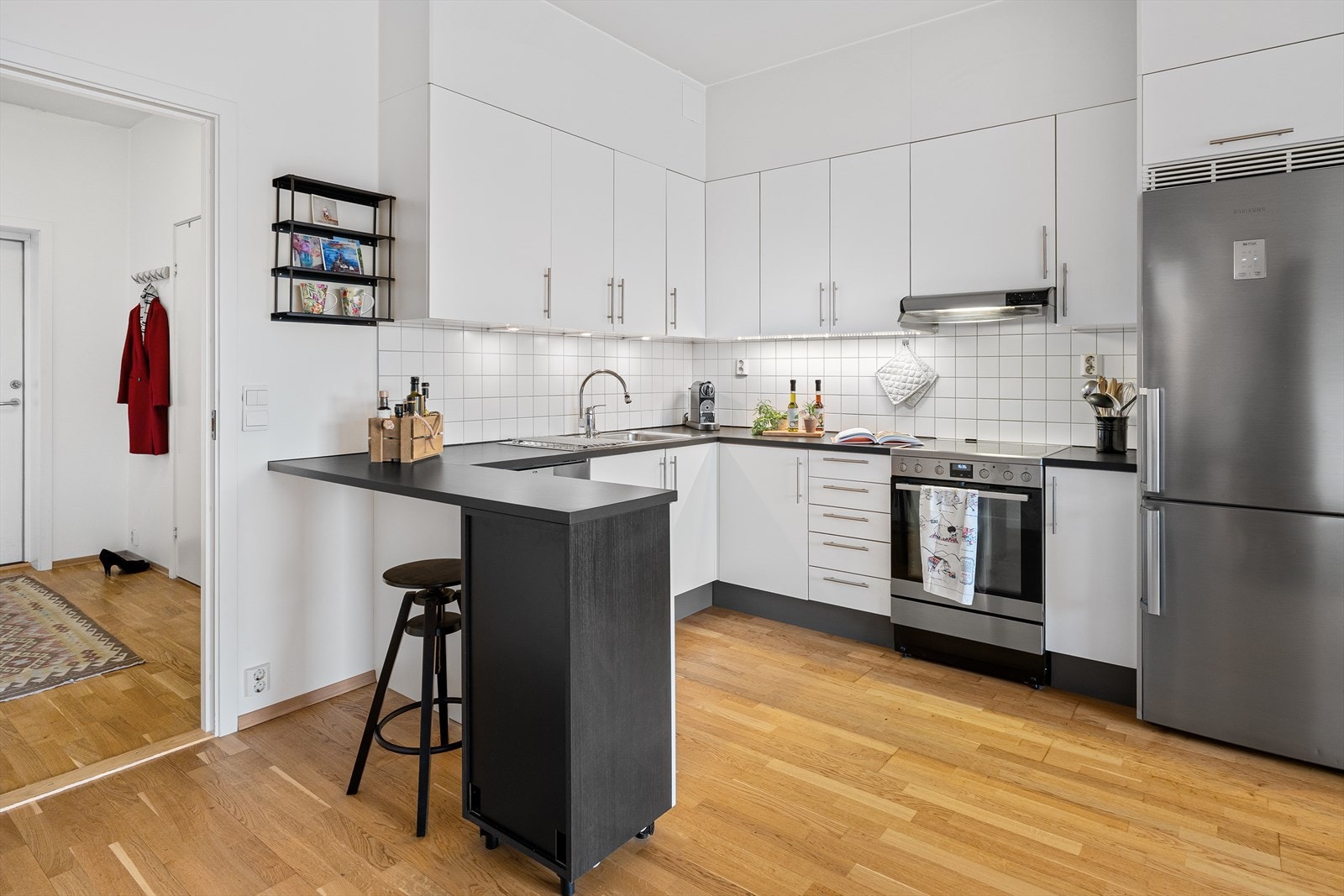 Pent kjøkken fra byggeår (2009) med lyse, glatte fronter. Galleribilde