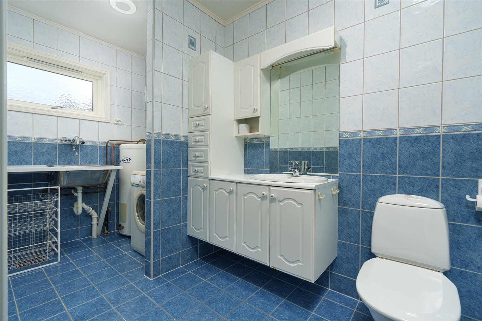 Praktisk vaskeromsnisje med opplegg for vaskemaskin, utslagsvask og bereder. Galleribilde
