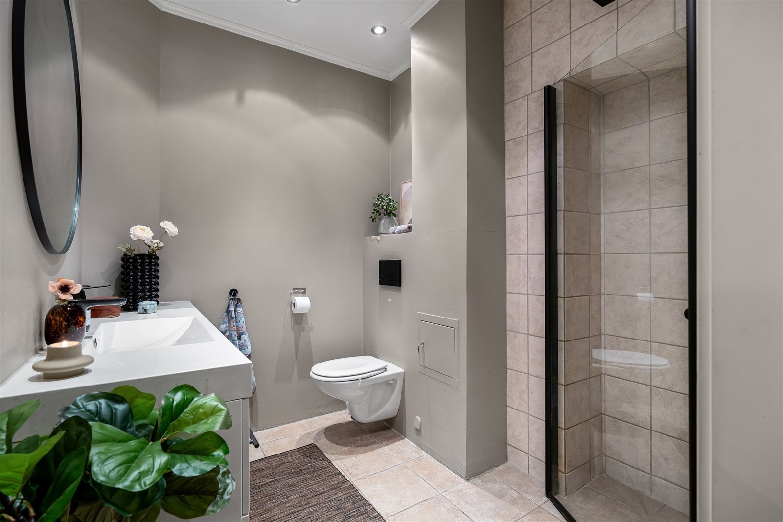 Badet er innredet med servant, dusj med glassdører og vegghengt toalett. Galleribilde