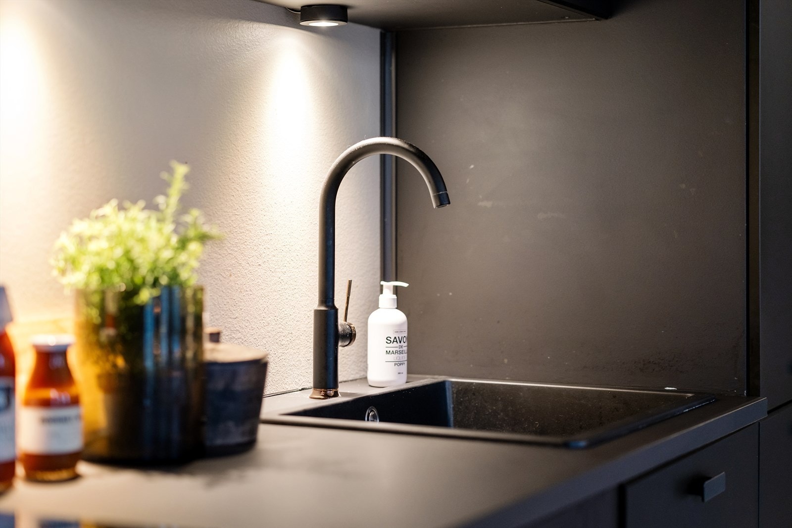 Laminat benkeplate med nedfelt kum i kompositt. Videre har kjøkkenet integrerte hvitevarer som stekeovn, platetopp, kjøl/frys og oppvaskmaskin. Galleribilde