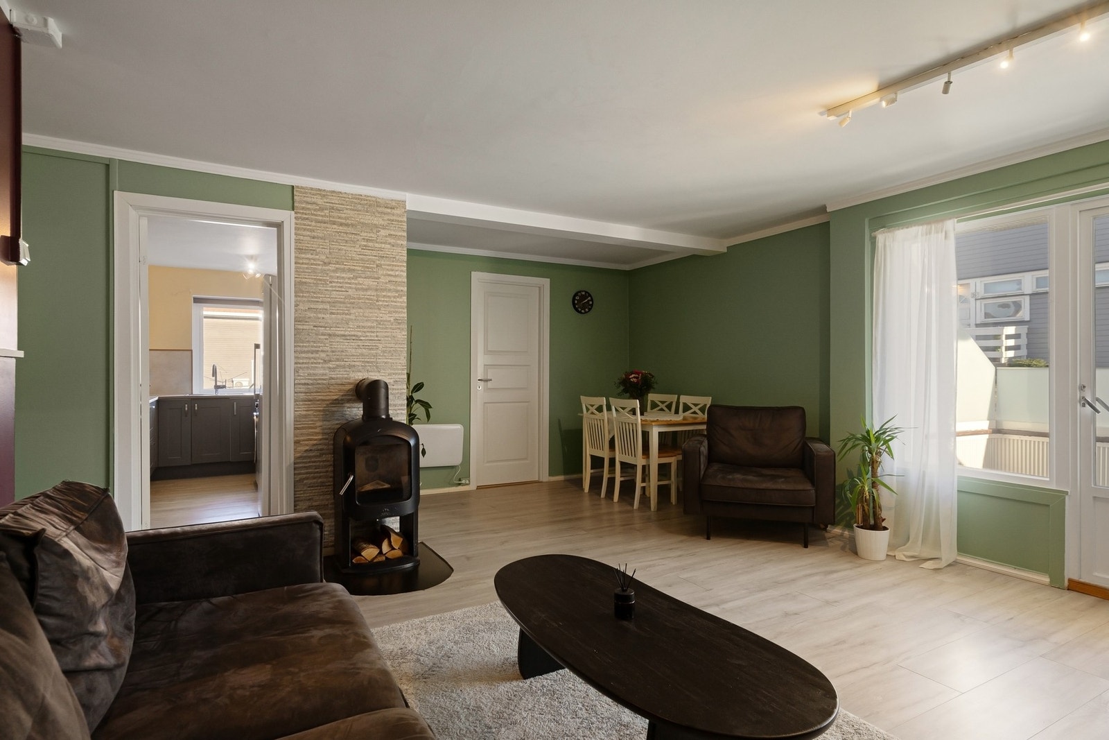 Koselig stue med peisovn og plass til sofagruppe og spisestue, og utgang til balkong. Galleribilde