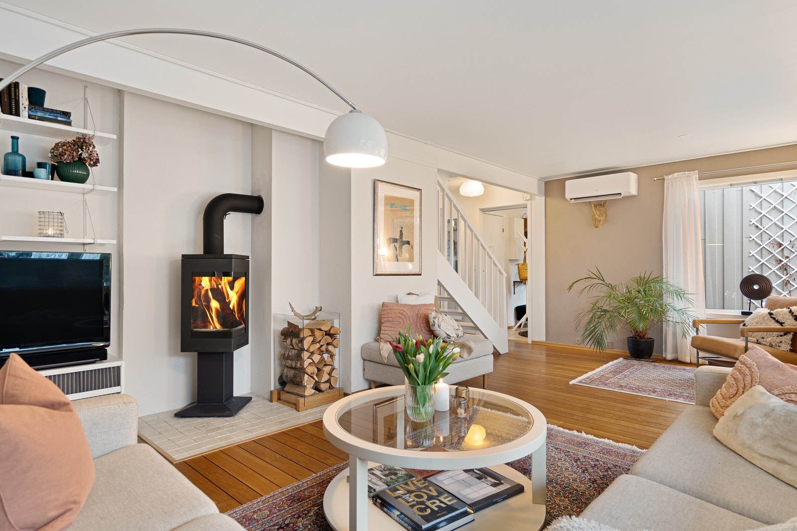 En peisovn fra 2012 med stort flammebilde skaper ekstra hygge, og en varmepumpe fra 2022 sørger for jevn temperatur. Galleribilde