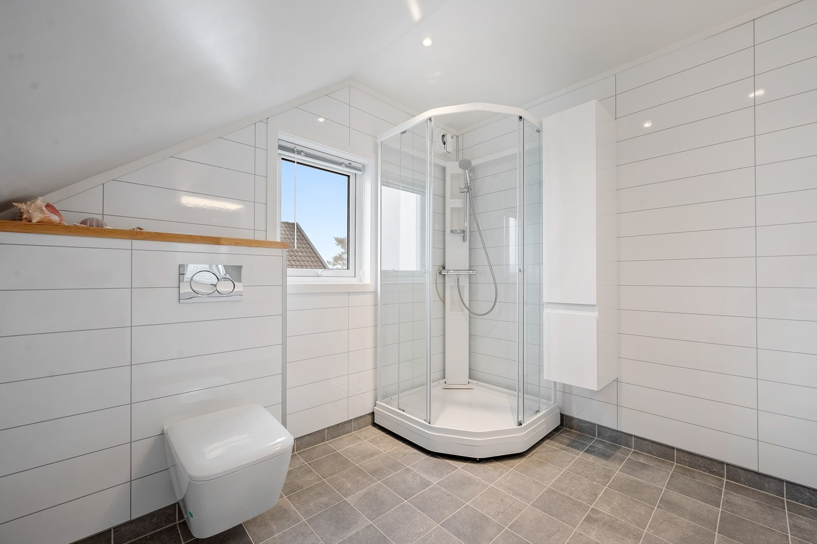 Bad i 2.etasje, innredet med dusjkabinett, vegghengt toalett og servant i møblement. Galleribilde