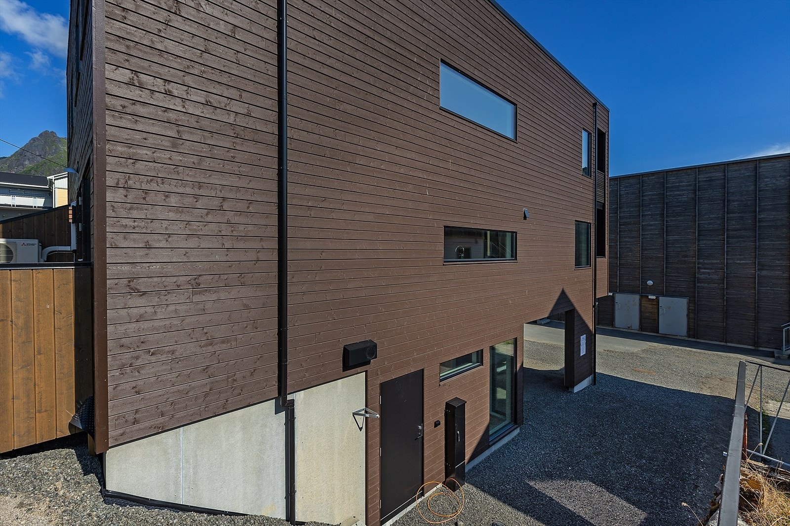 Boligen har boddør mot sør og gårdsplassen er asfaltert og noe gruset og opparbeidet mot nabo. Galleribilde