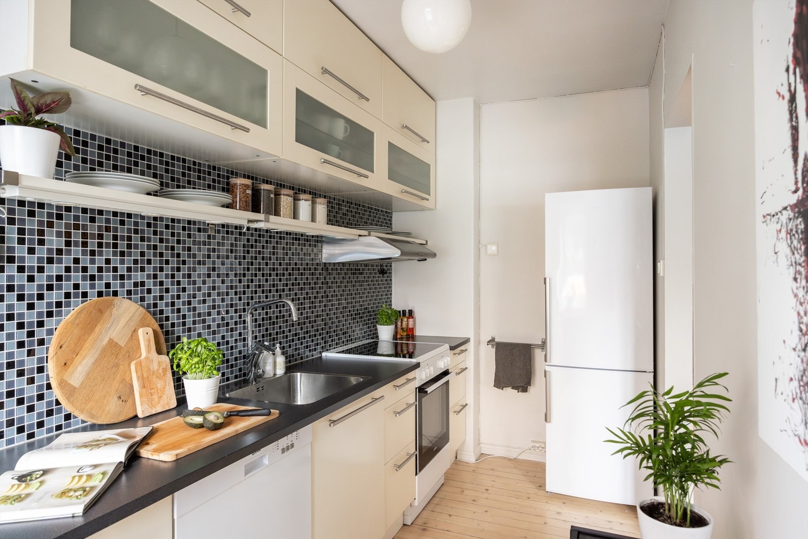 - Kjøkkeninnredning med glatte fronter. Laminat benkeplate med nedfelt vask. Kullfilterventilator over kokeplass - Galleribilde