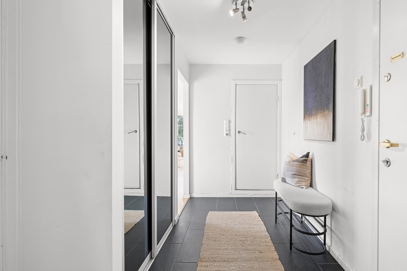 Romslig entré med plassbesparende skyvedørsgarderobe. Galleribilde