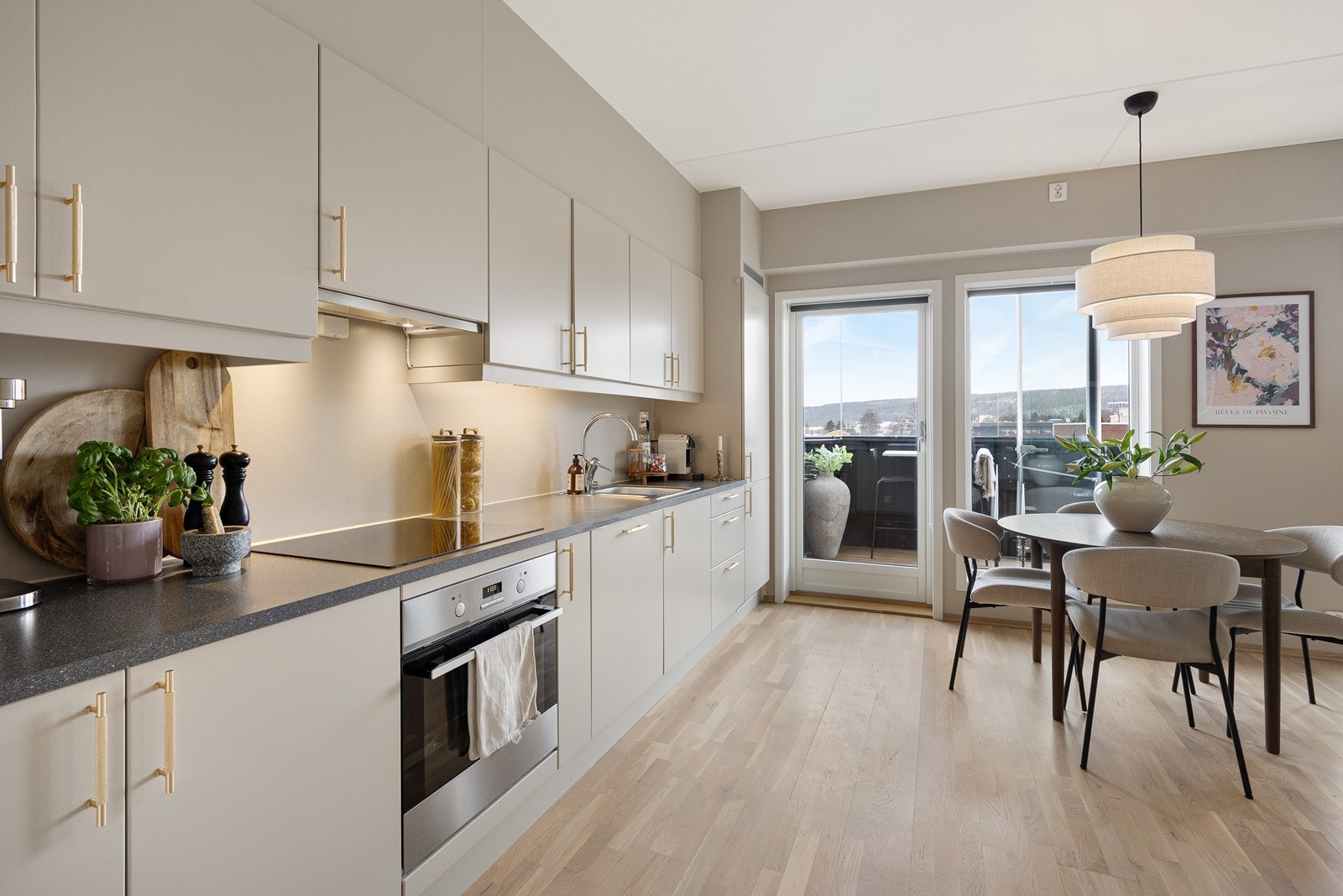 Kjøkkenet fra Aubo er utført i lekker og moderne stil med beige glatte fronter og moderne håndtak i messing. Galleribilde