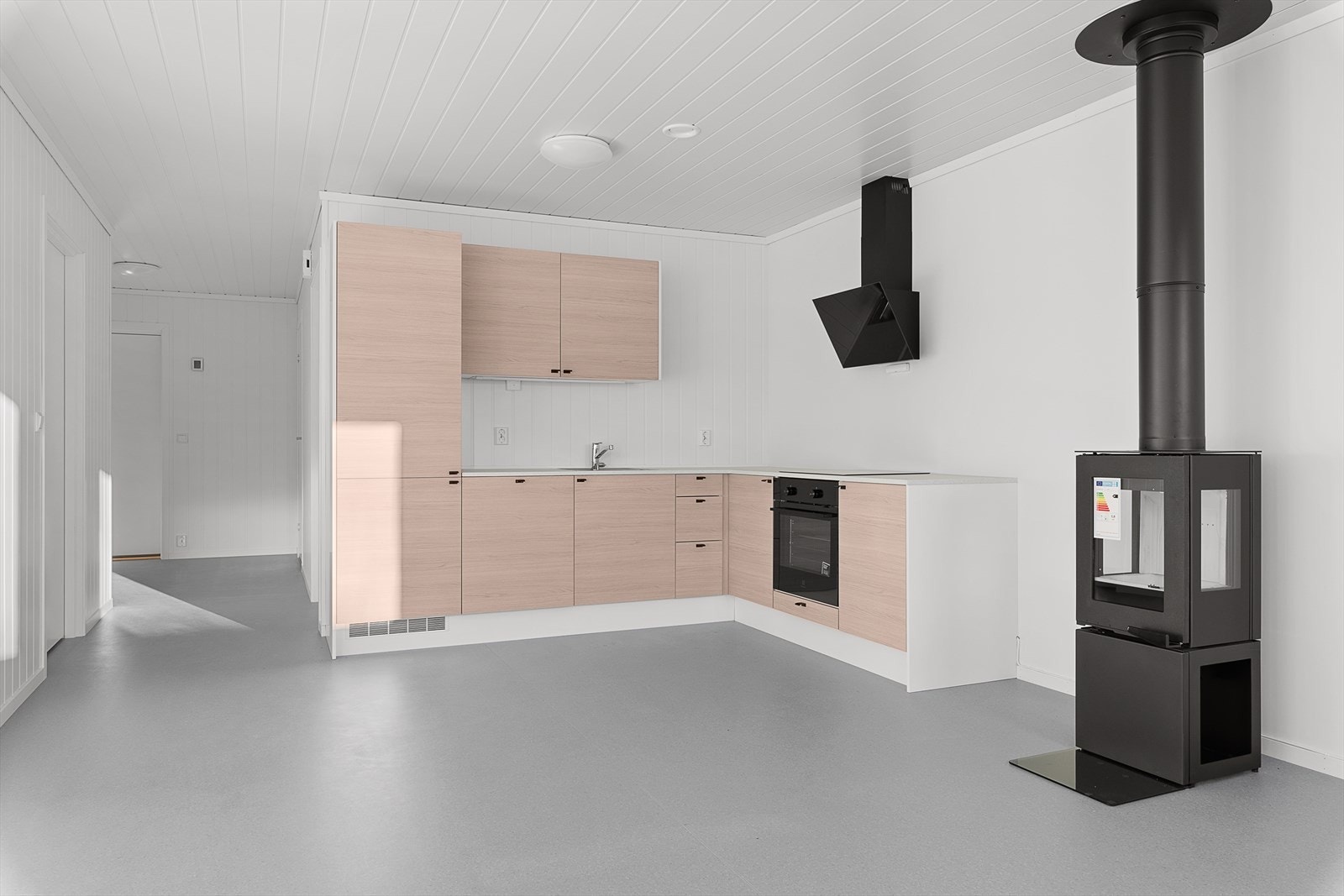 Kjøkkenet er lyst og moderne, og inneholder integrerte hvitevarer. Pen kjøkkeninnredning med glatte fronter Galleribilde