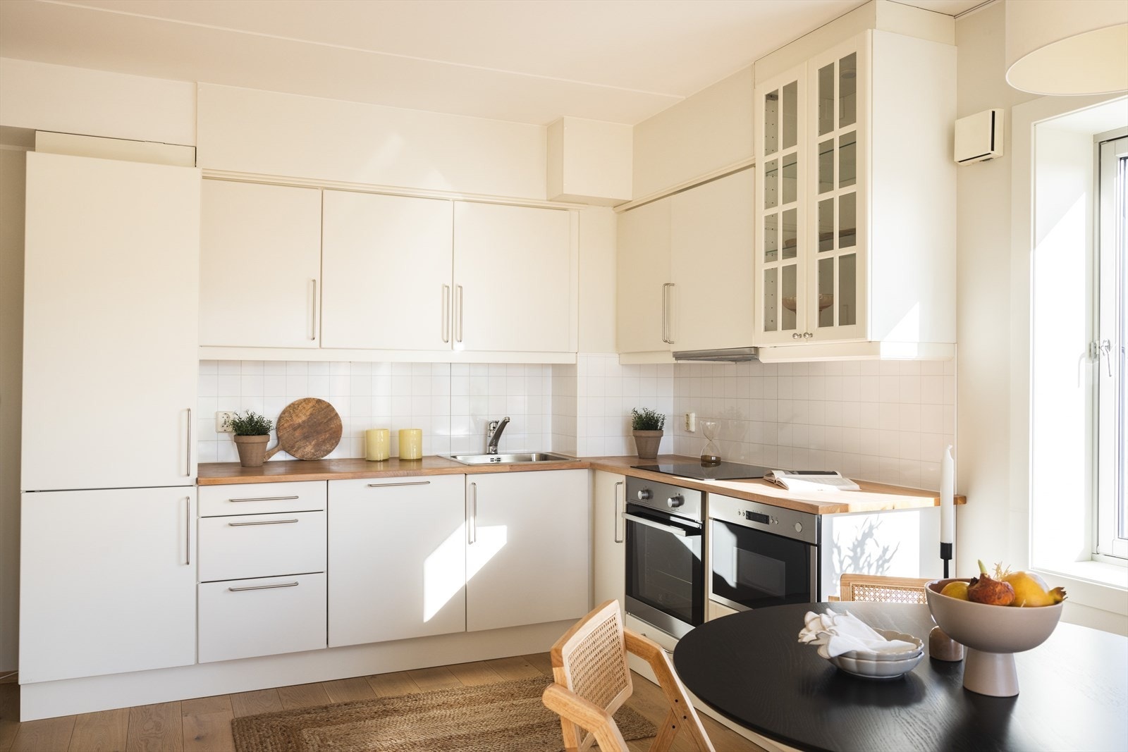 Lyst og moderne kjøkken med integrerte hvitevarer og godt med skapplass Galleribilde