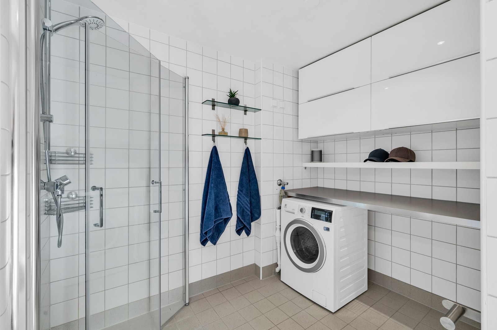 Innredningen består av vegghengte servantskap med nedfelt servant. Videre har badet vegghengt toalett og dusjhjørne med innfellbare glassdører. Galleribilde