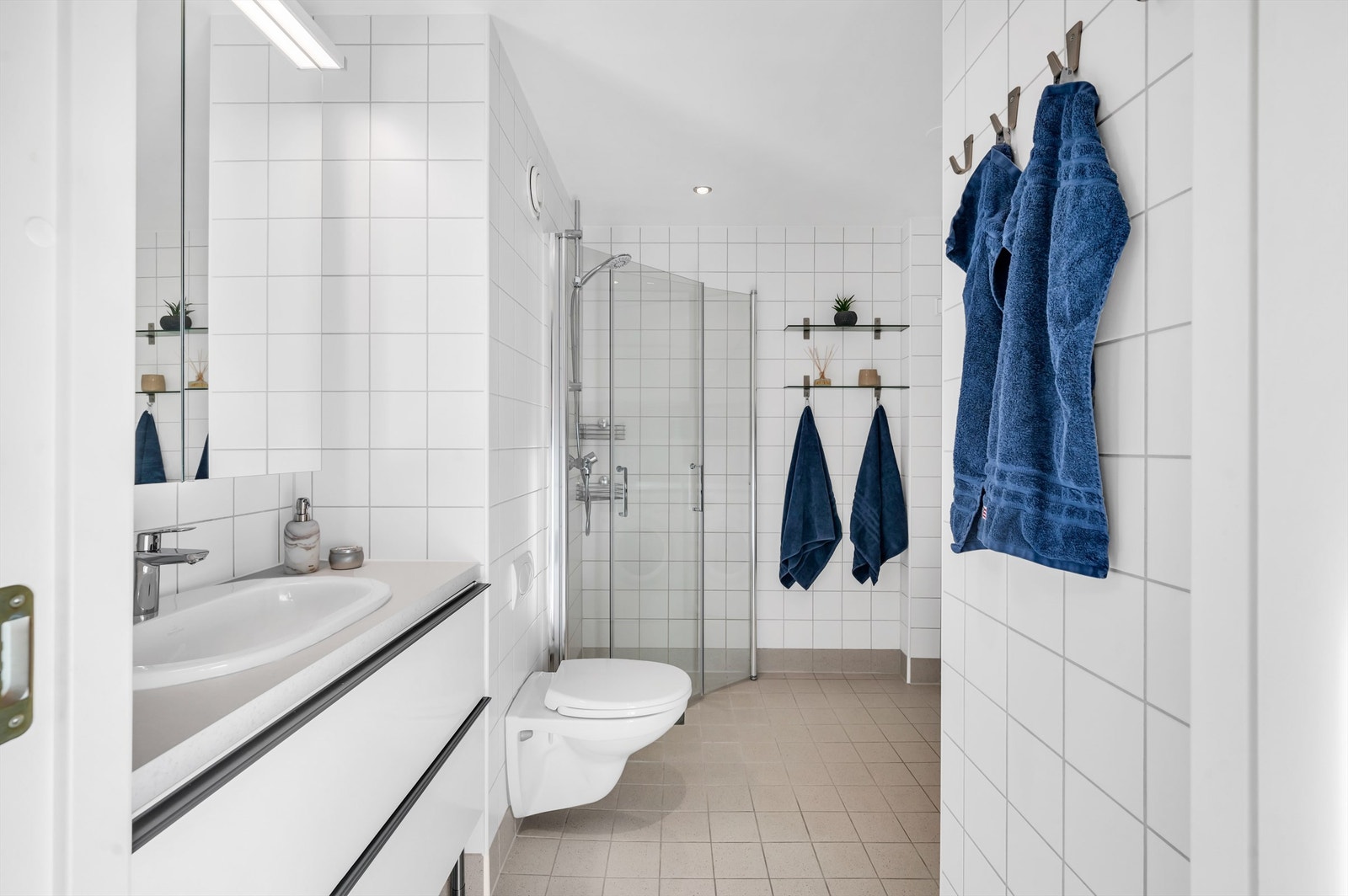 Badet er pent flislagt på gulv og vegger med varme i gulvet. Galleribilde