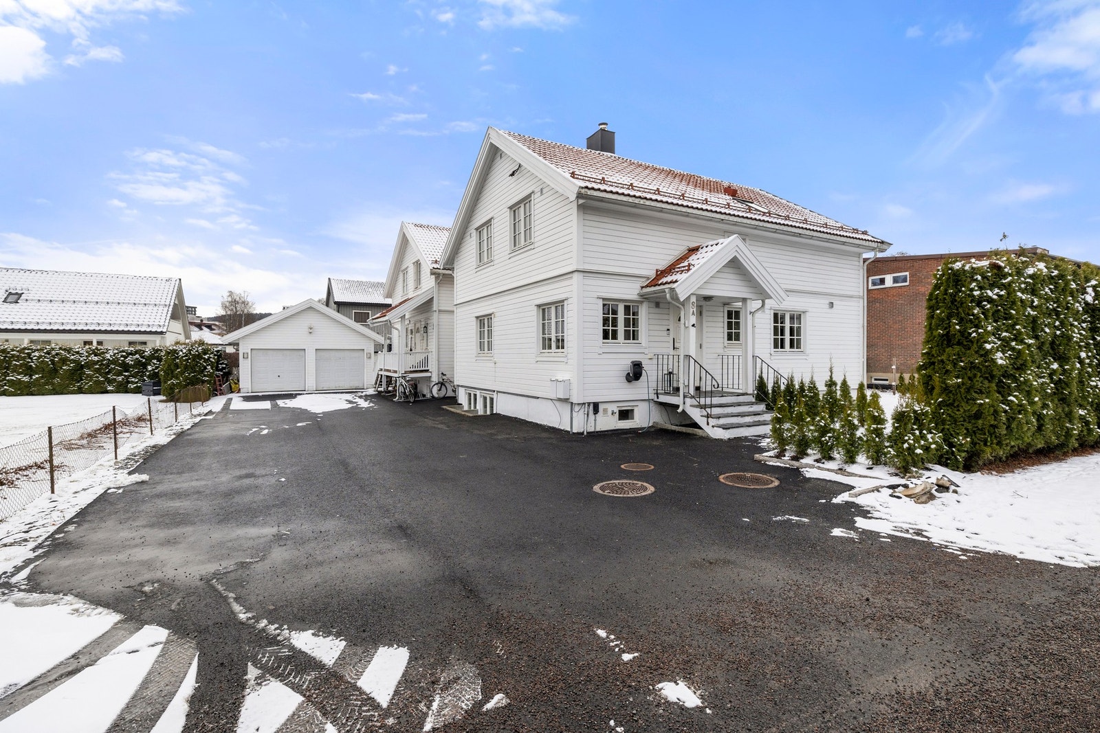Eiendommen har en asfaltert oppstillingsplass med plass til tre biler foran garasjen. Felles garasje med egen elbillader på utsiden. Galleribilde