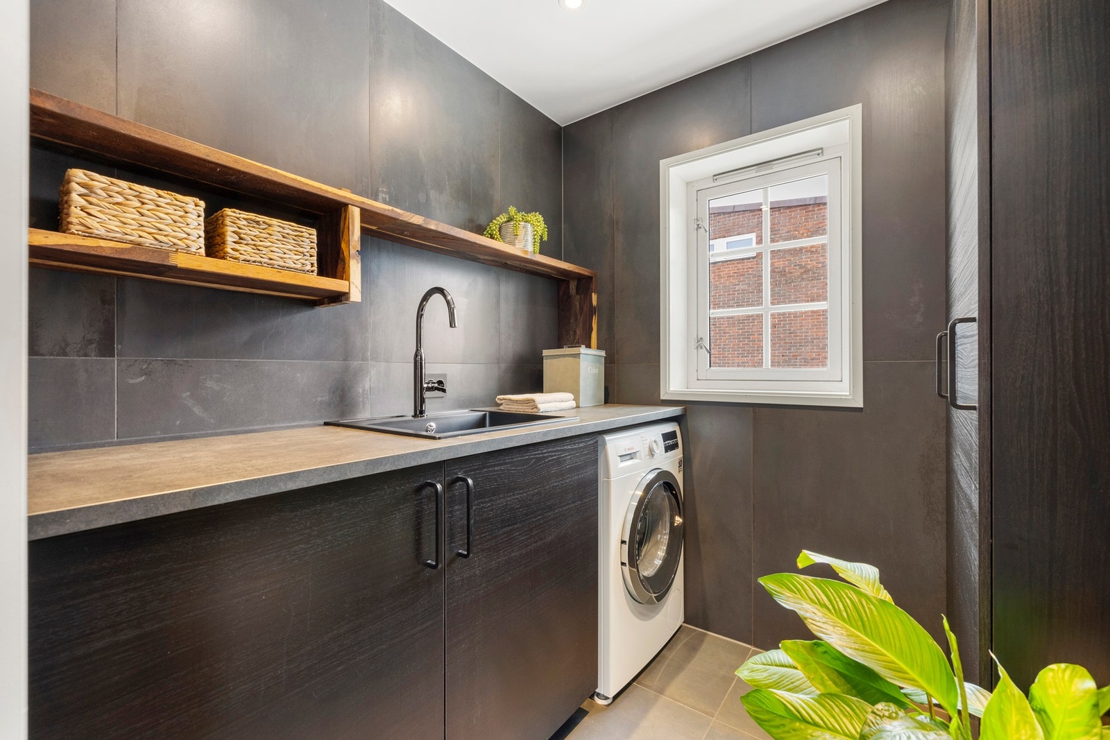 Moderne og innbydende vaskerom med gulvvarme og stilrene detaljer. Galleribilde