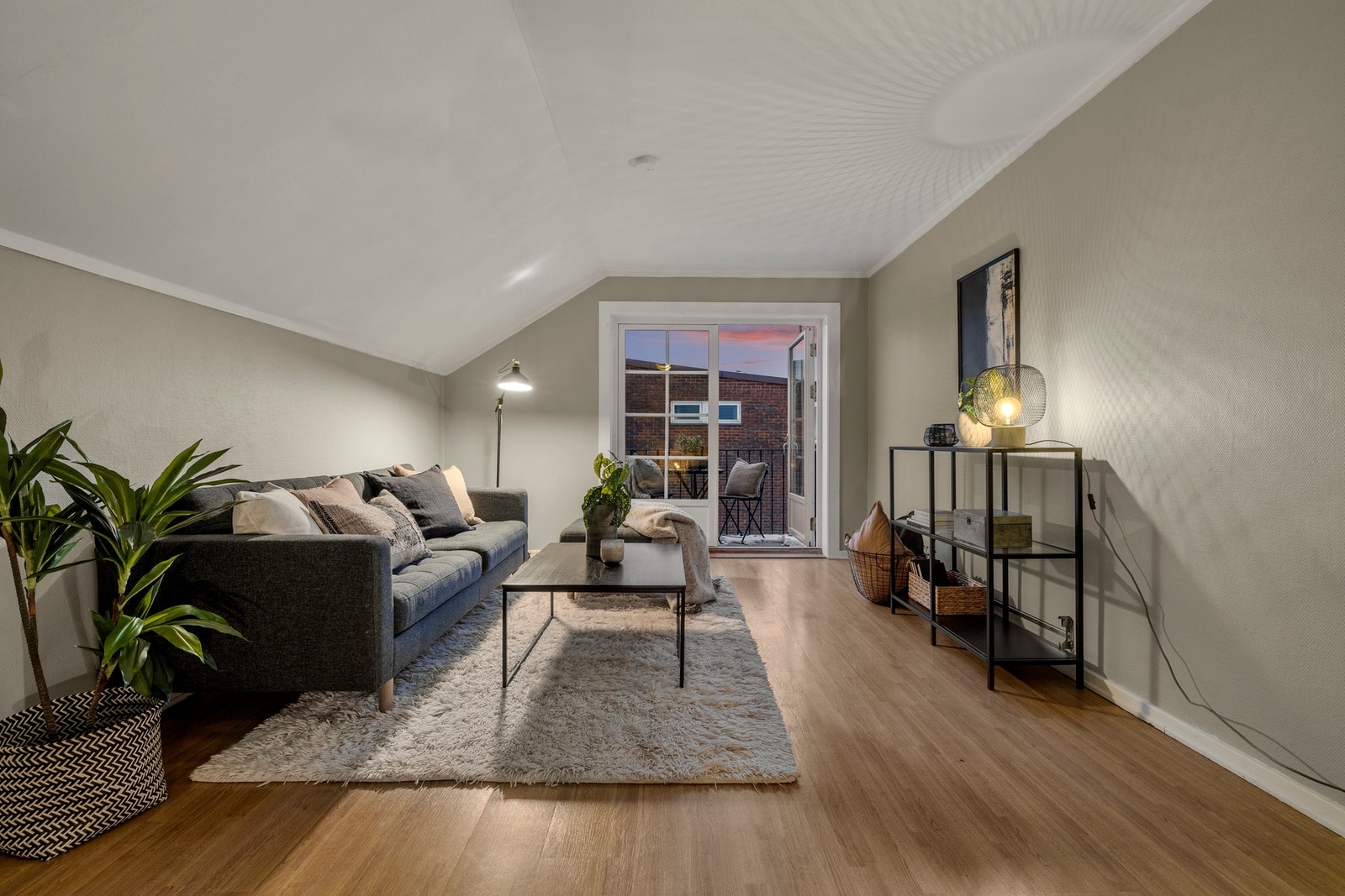 En romslig og lys loftsstue med god takhøyde og store vinduer med utgang til balkong. Galleribilde