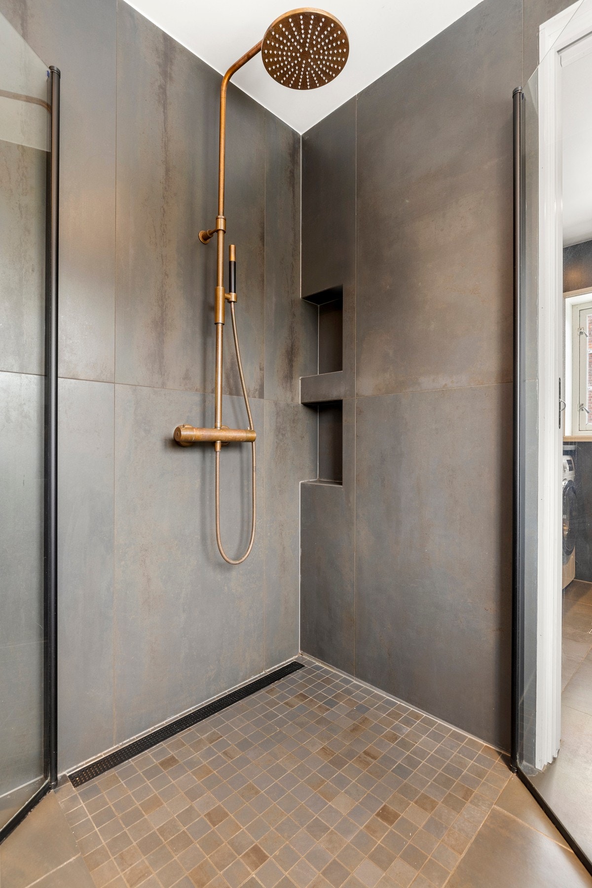 En romslig dusjsone med integrerte hyller og lekre detaljer. Galleribilde